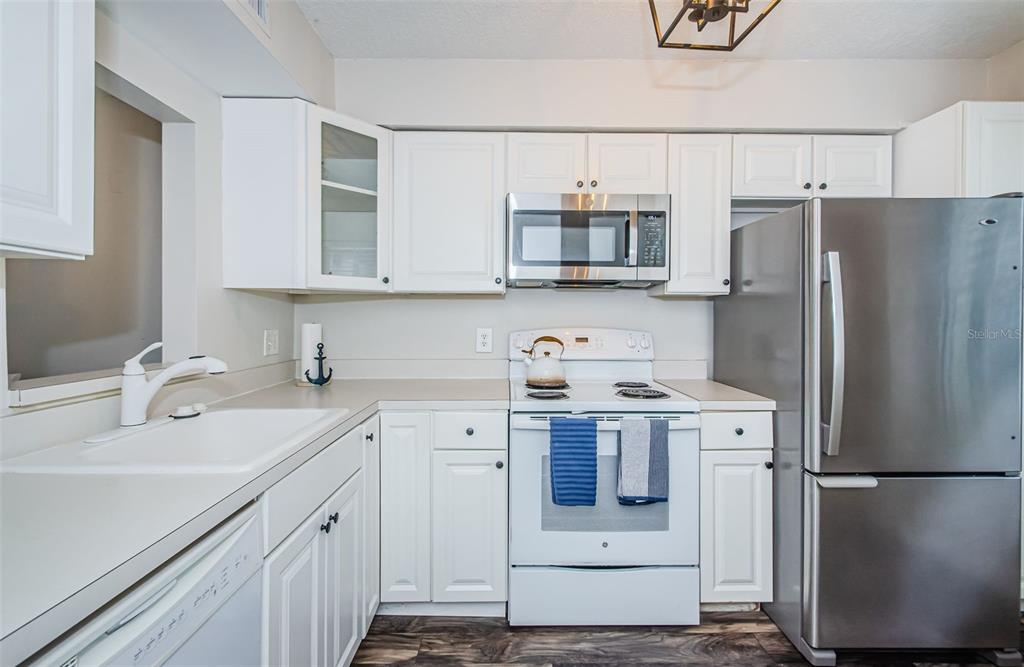 3716 Trophy Boulevard, Unit 3716 New Port Richey, FL 34655 - Photo 4 of 56 a kitchen with stainless steel appliances a refrigerator stove microwave and sink