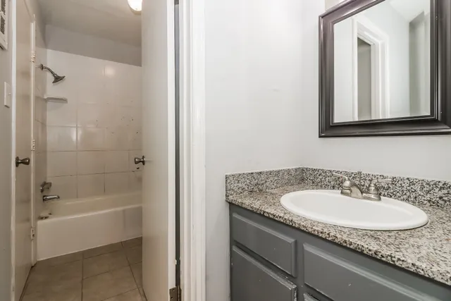 a bathroom with a granite countertop sink and a mirror