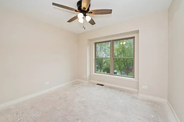 an empty room with a window and a fan