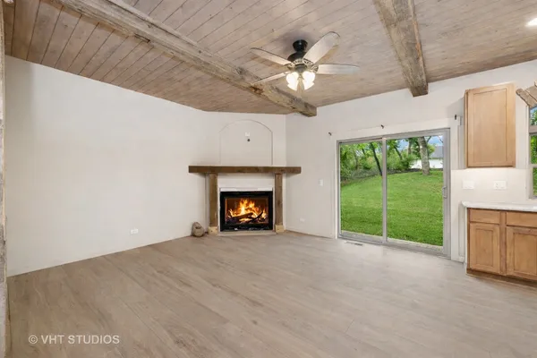 a view of an empty room with a fireplace and a window