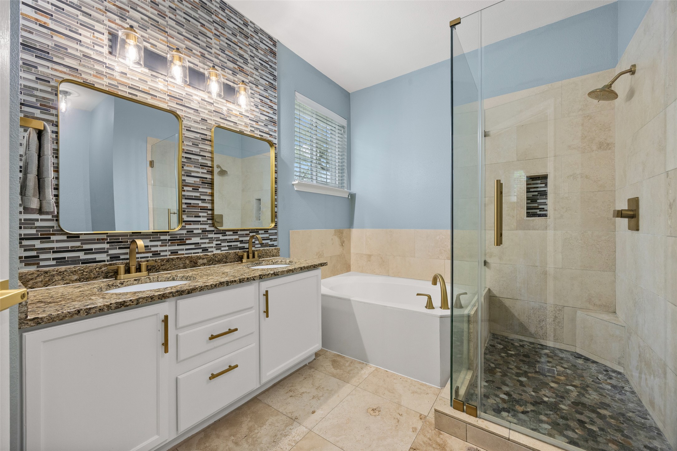 8610 Axis Drive Austin, TX 78749 - Photo 7 of 29 a bathroom with a double vanity sink a mirror and a bathtub