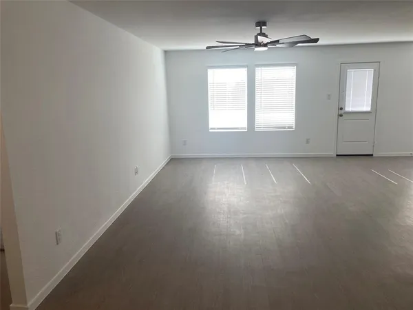 an empty room with windows and cabinet