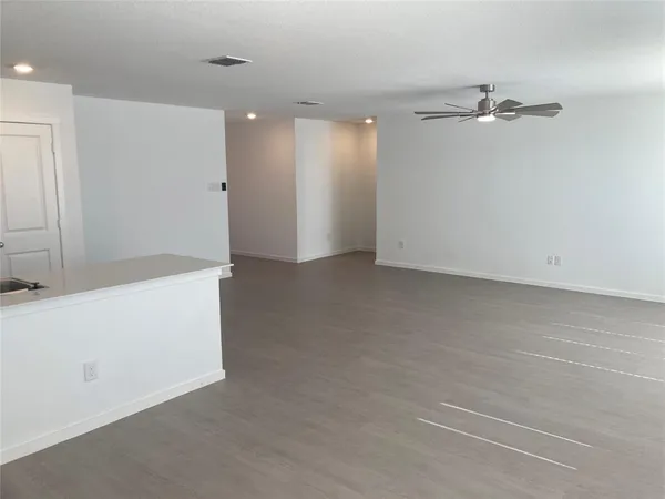 a view of an empty room with a ceiling fan