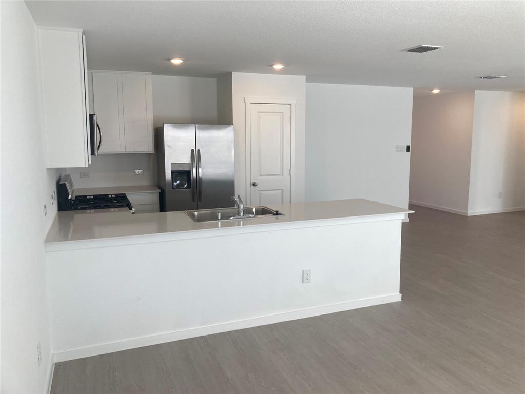 1520 Elliott Road Howe, TX 75459 - Photo 16 of 29 a large kitchen with kitchen island granite countertop a sink a refrigerator and a stove