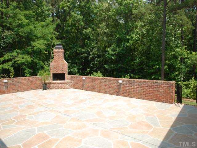 1005 Farnsworth Road Wake Forest, NC 27587 - Photo 20 of 25 The stone patio with masonry fireplace is an ideal location to entertain while overlooking the private and wooded 2.28 acres.