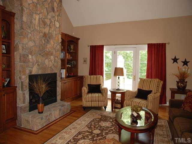 1005 Farnsworth Road Wake Forest, NC 27587 - Photo 2 of 25 Gorgeous family room has beautiful hardwoods with decorative inlay, floor to ceiling stone fireplace with gas logs, custom built-ins, vaulted ceilings, and leads to the amazing deck.