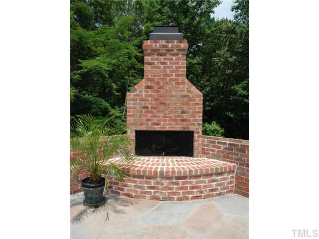 1005 Farnsworth Road Wake Forest, NC 27587 - Photo 21 of 25 The stone patio with masonry fireplace is an ideal location to entertain while overlooking the private and wooded 2.28 acres.