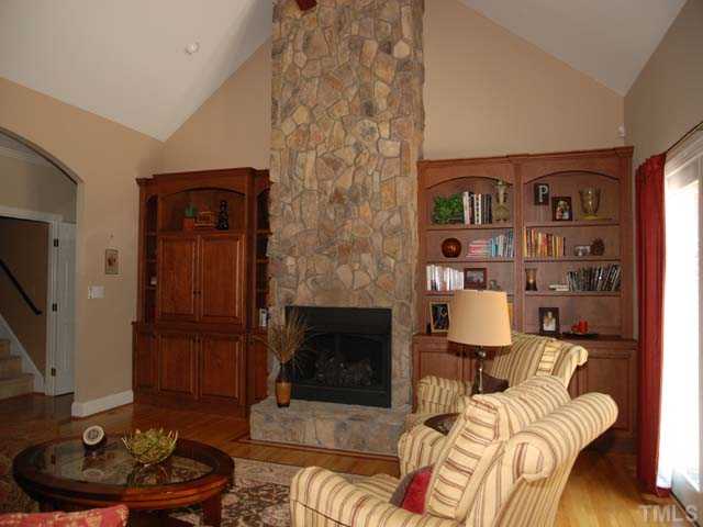 1005 Farnsworth Road Wake Forest, NC 27587 - Photo 3 of 25 Gorgeous family room has beautiful hardwoods with decorative inlay, floor to ceiling stone fireplace with gas logs, custom built-ins, vaulted ceilings, and leads to the amazing deck.