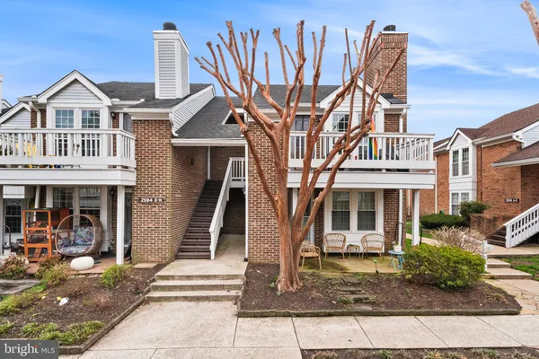 a front view of a house with a tree