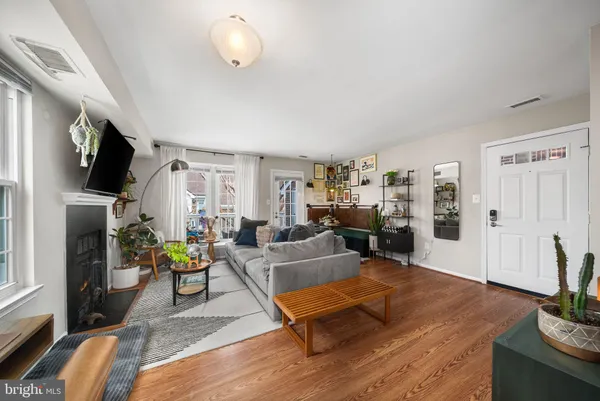 a living room with furniture a flat screen tv and a refrigerator