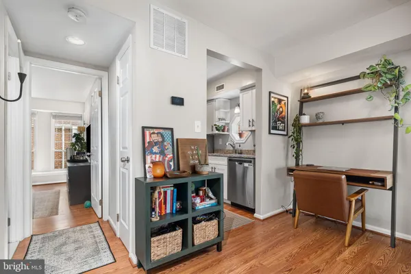 a view of a workspace with furniture and wooden floor