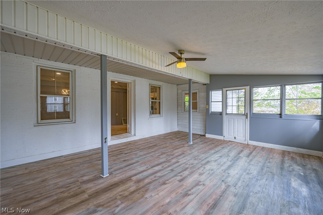 39016 Detroit Road Avon, OH 44011 - Photo 13 of 36 Empty room with vaulted ceiling, ceiling fan, hardwood / wood-style flooring, and a textured ceiling