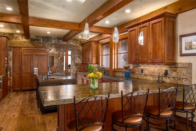 a kitchen with a dining table chairs and wooden floor