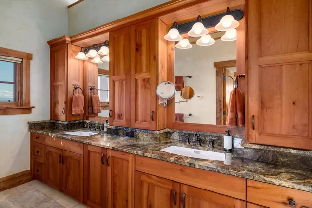 a bathroom with a granite countertop sink and a mirror