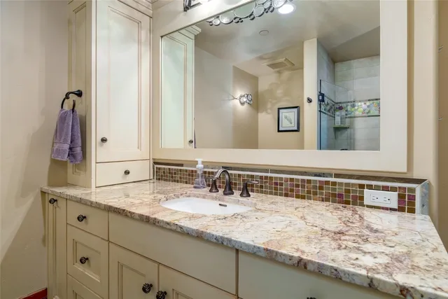 a bathroom with a granite countertop sink and a mirror