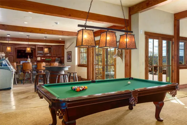 a room with pool table and windows