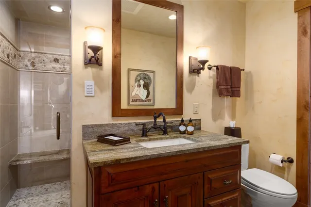 a bathroom with a granite countertop sink toilet and shower