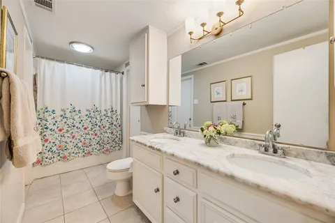 a bathroom with a granite countertop sink a toilet and a mirror