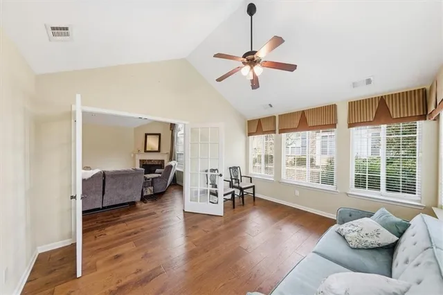 a living room with furniture and a large window with wooden floor