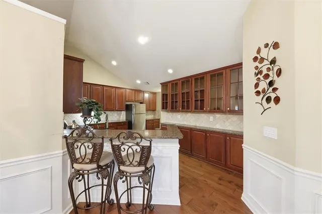 a kitchen with stainless steel appliances granite countertop wooden cabinets a stove top oven a sink and dishwasher