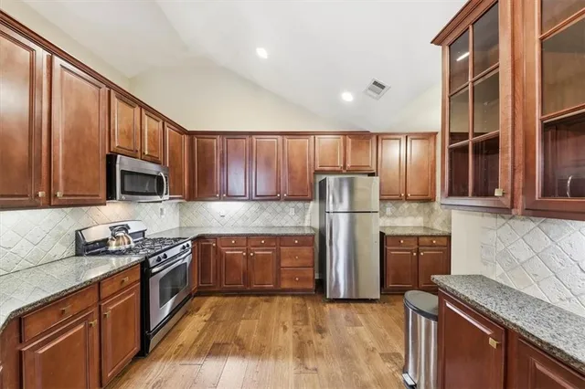 a kitchen with stainless steel appliances granite countertop a sink stove and cabinets