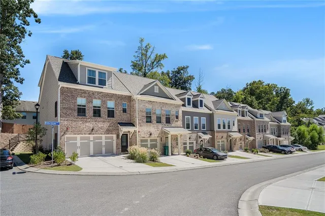 a front view of a building with a garden and mountain view