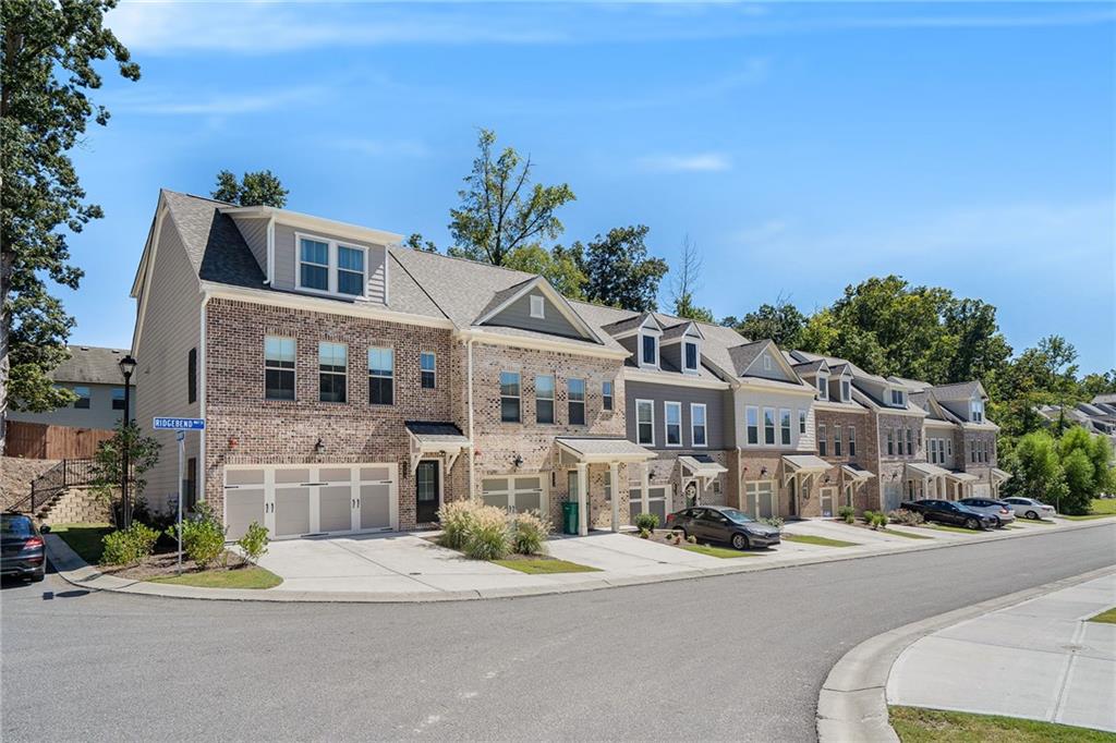 a front view of a building with a garden and mountain view