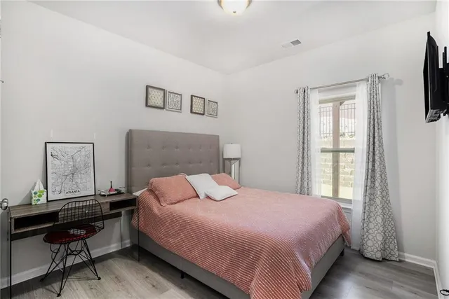 a bedroom with a bed a computer on desk and a window