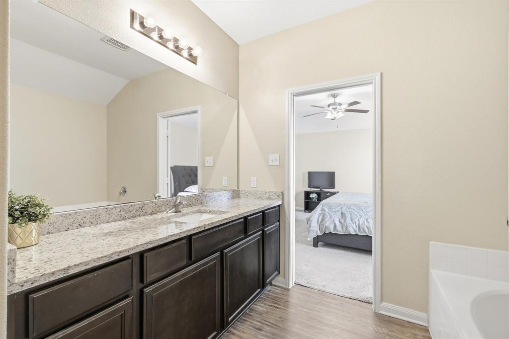 227 Curt Street Anna, TX 75409 - Photo 23 of 40 Ensuite bathroom with a tub, vanity, light wood-style flooring, and ceiling fan