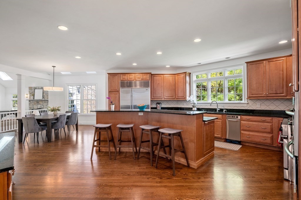 10 Forest Hill Road Wayland, MA 01778 - Photo 8 of 41 a kitchen with stainless steel appliances granite countertop a table chairs sink and wooden floor