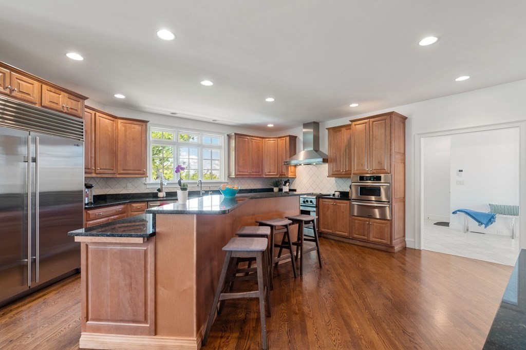 10 Forest Hill Road Wayland, MA 01778 - Photo 9 of 41 a kitchen with stainless steel appliances granite countertop wooden cabinets a refrigerator a stove a sink and a chairs