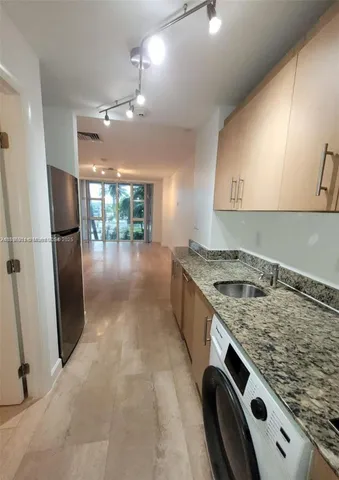 a kitchen with a stove a refrigerator and a sink