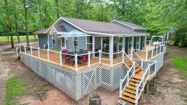 a view of a house with wooden deck and furniture