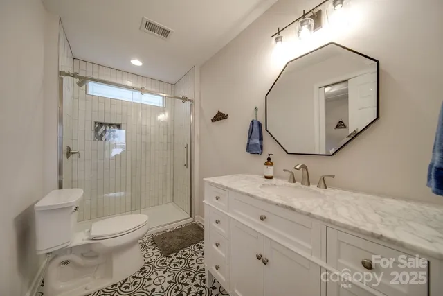 a bathroom with a toilet a sink and glass door