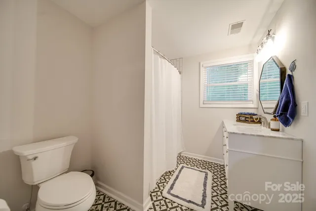a bathroom with a toilet a sink and a window