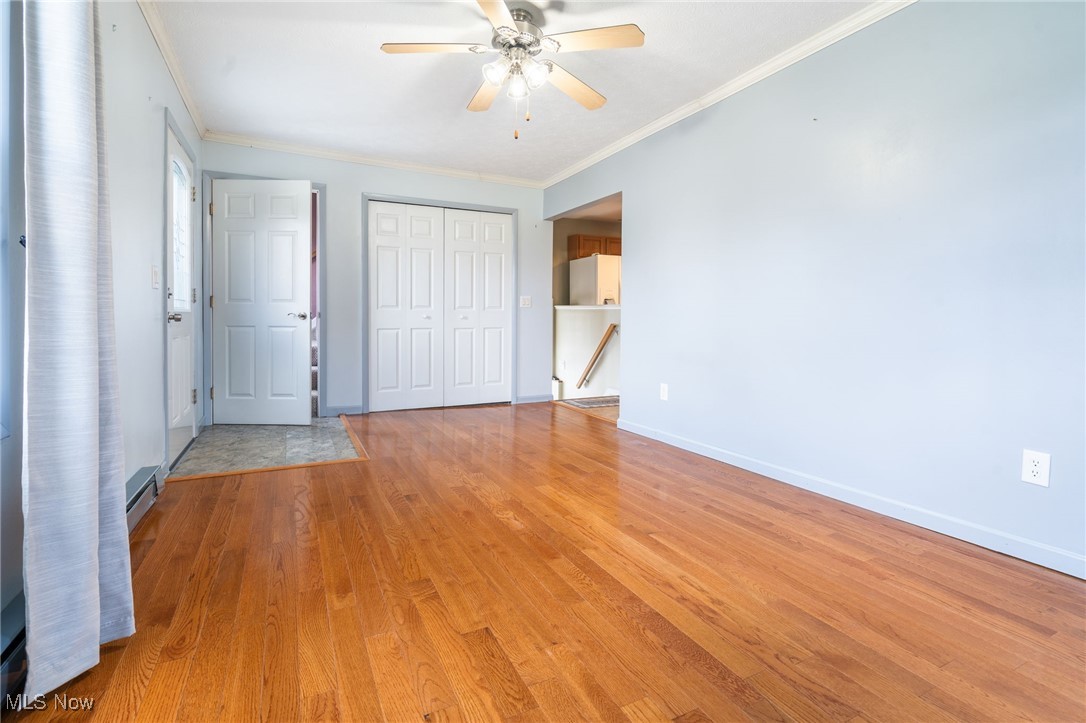 3696 Lynn Road Ravenna, OH 44266 - Photo 7 of 25 Unfurnished bedroom featuring ceiling fan, light wood-type flooring, ornamental molding, white fridge, and a closet