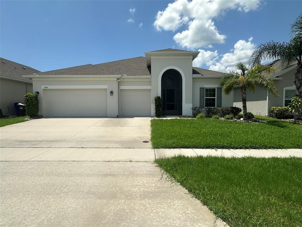 a front view of a house with a yard and garage