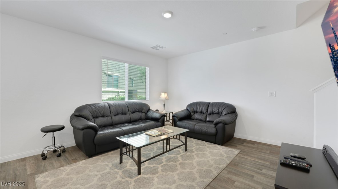 12346 Indigo Montage Road, Unit 4 Las Vegas, NV 89183 - Photo 12 of 27 Living area featuring wood finished floors and baseboards