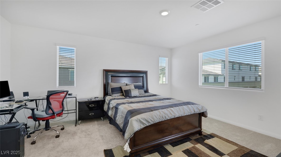 12346 Indigo Montage Road, Unit 4 Las Vegas, NV 89183 - Photo 16 of 27 Bedroom with light colored carpet, multiple windows, and an office area