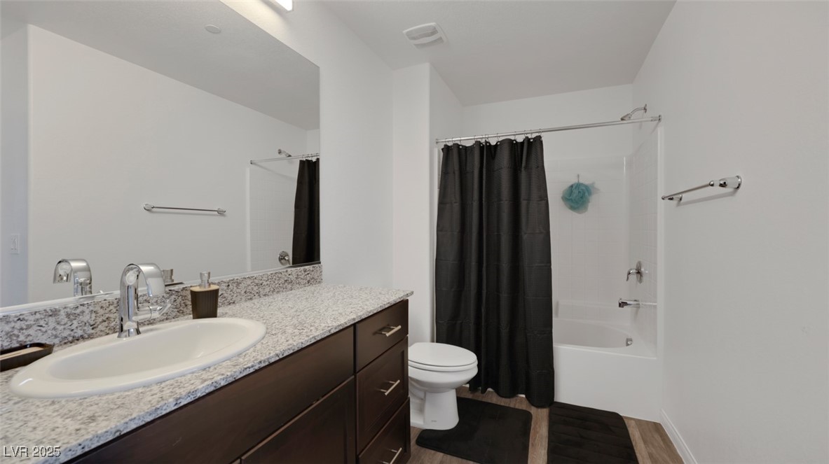 12346 Indigo Montage Road, Unit 4 Las Vegas, NV 89183 - Photo 19 of 27 Full bathroom with shower / tub combo with curtain, vanity, and dark wood-style flooring