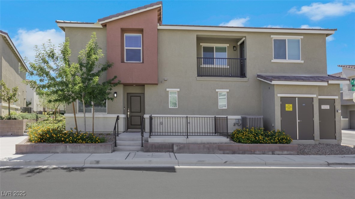12346 Indigo Montage Road, Unit 4 Las Vegas, NV 89183 - Photo 2 of 27 View of front facade featuring stucco siding, a balcony, a fenced front yard, and a gate