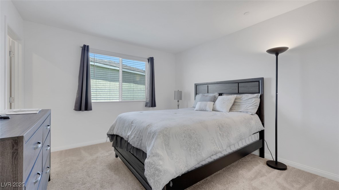12346 Indigo Montage Road, Unit 4 Las Vegas, NV 89183 - Photo 24 of 27 Bedroom featuring light colored carpet and baseboards