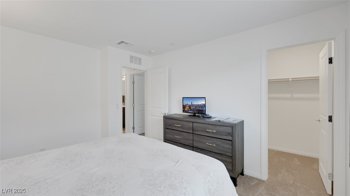 12346 Indigo Montage Road, Unit 4 Las Vegas, NV 89183 - Photo 25 of 27 Bedroom with light colored carpet and a walk in closet