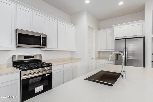 a large kitchen with stainless steel appliances a sink and a counter top space