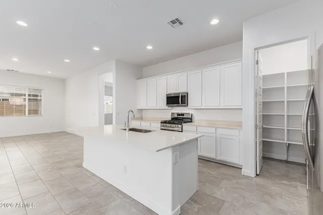 a kitchen with cabinets stainless steel appliances and wooden floor