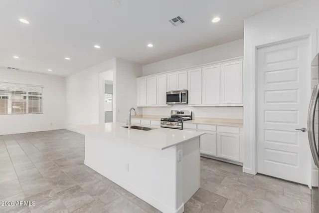 a view of a kitchen with granite countertop a large window and stainless steel appliances