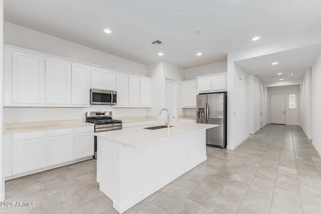 a large kitchen with stainless steel appliances and a refrigerator