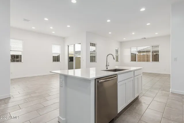 a large white kitchen with stainless steel appliances
