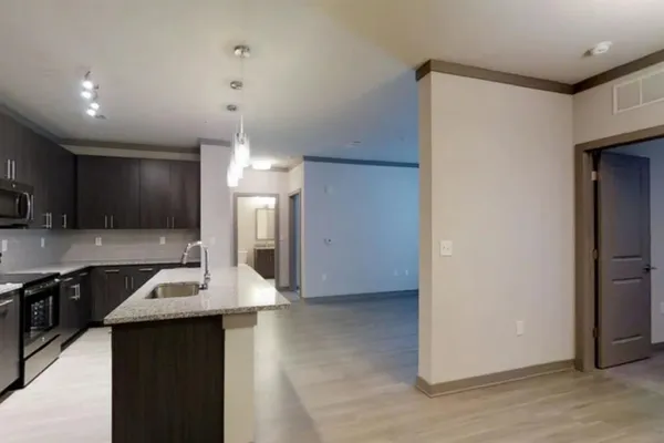 a kitchen with kitchen island a counter top space a sink stainless steel appliances and cabinets