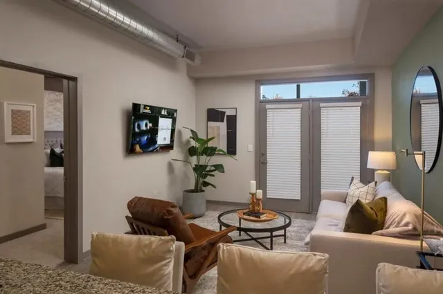 a living room with furniture and a wooden floor